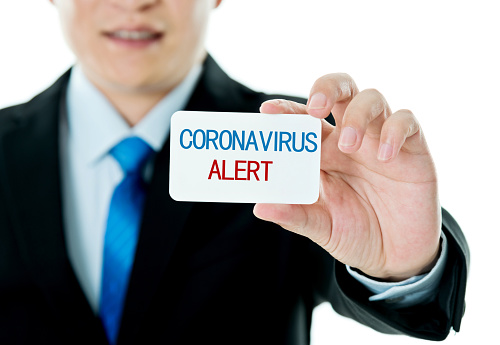 Businessman showing a card to alert against coronavirus.