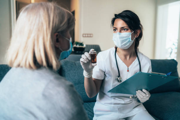 Doctor's home visiting during the quarantine Female doctor consults mature patient during the quarantine for coronavirus antiviral drug stock pictures, royalty-free photos & images