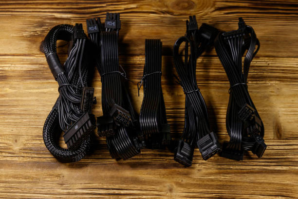 istock Set of cables for computer PSU on a wooden desk 1215678245