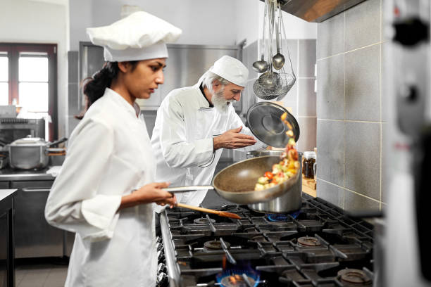 istock Head chef and sous chef cooking together in the kitchen 1215678314