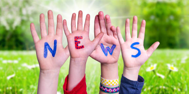 mani dei bambini costruzione di notizie word, prato erboso - teamwork concepts article communication foto e immagini stock