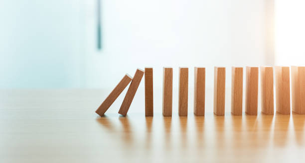 istock Domino pieces is falling on wooden table 1215678986