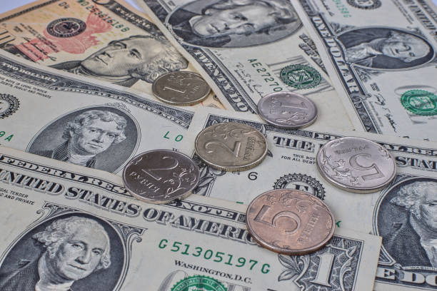 istock coin ruble on the background bills dollar. 1215680685