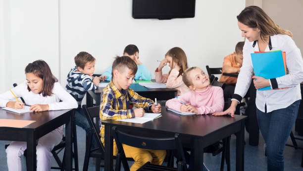 istock Little children with teacher in classroom 1215680728