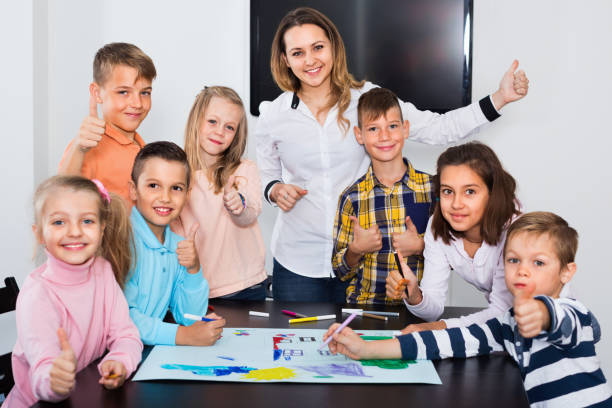 istock Children with teacher drawing together in classroom 1215680744