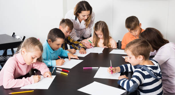 istock Boys and girls with teacher drawing 1215681619