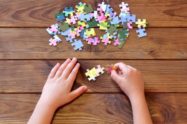 istock Child holding multicolor puzzles in hands. Education concept. Top view 1215683383