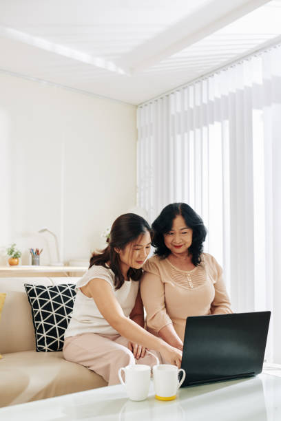 istock Woman explaining mother how to send e-mails 1215683426