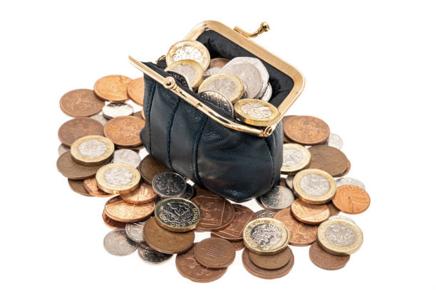 Ladies black leather purse overflowing with coins - white background