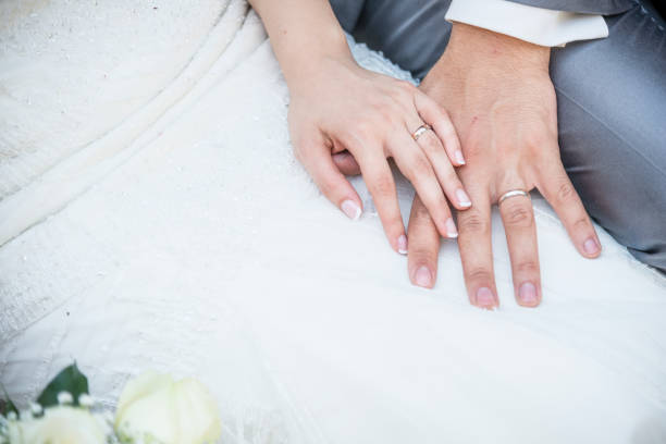 hands of a just married couple with the wedding rings stock photo