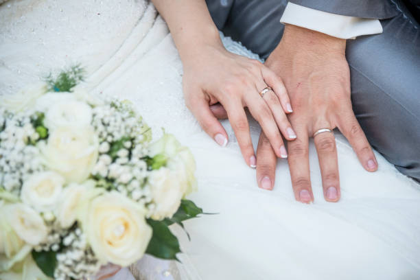 manos de una pareja recién casada con los anillos de boda - esposa cónyugue fotos fotografías e imágenes de stock