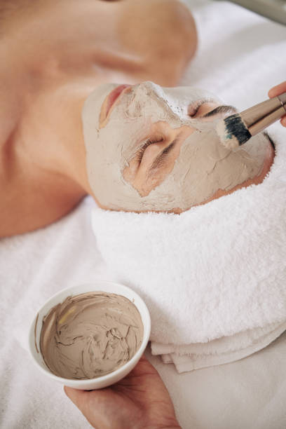 грязевая маска приложение - mud wellbeing spa treatment beautician стоковые фото и изображения