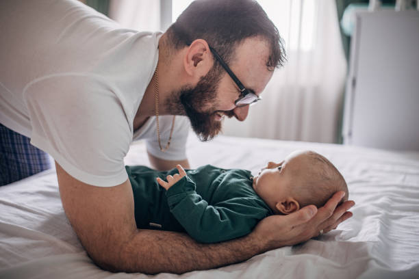 istock Father playing with his baby son on bed at home 1215685336