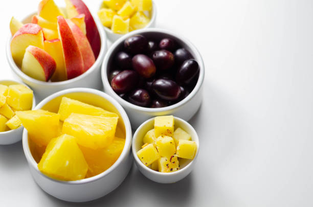 istock Various set fruits, pineapple, apple, grapes with matured cheddar cheese in bowls 1215685473