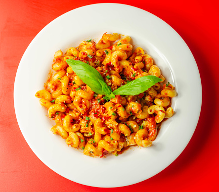 Cooked cellentani pasta with cooked chicken breast and peppers in a spicy tomato and jalapeno dressing