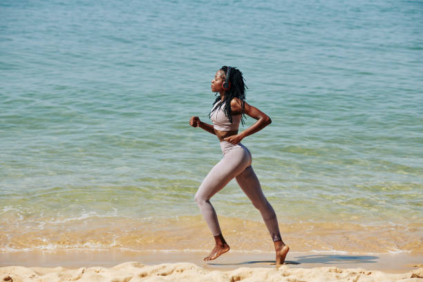 istock Woman jogging on the beach 1215685882