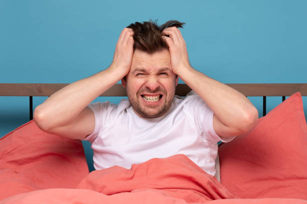 istock Stressed handsome young man sitting in the bed alone feeling unhappy and tired. 1215688197
