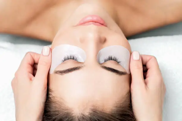 Photo of Hands glues ribbon under eyes.