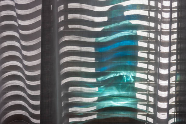 istock Sun shining through a blue bottle and partially open blinds 1215690050
