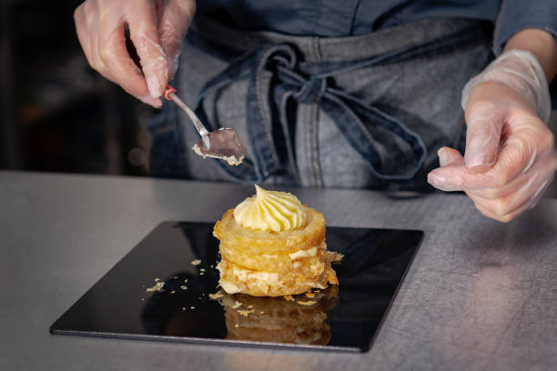 istock Confectioner makes a cake with cream and raspberries. 1215690711