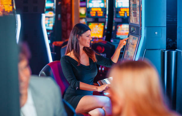 istock Elegant woman playing on slot machine 1215692949
