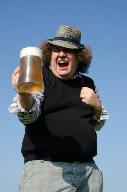 istock Funny fat man is drinking beer. 1215693311