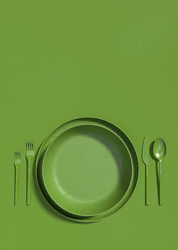 Empty green plate and cutlery on a green table. Monochrome vertical illustration of a table serving on a top view. Copy space. 3D rendering