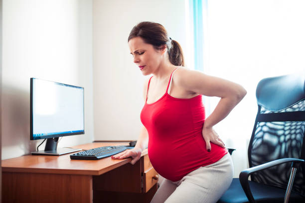 schwangere frau mit rückenschmerzen zu hause - window human pregnancy home interior women stock-fotos und bilder