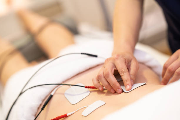 Electro stimulation in physical therapy to a young woman Physiotherapist applying electro stimulation in physical therapy to a young woman. electrode stock pictures, royalty-free photos & images