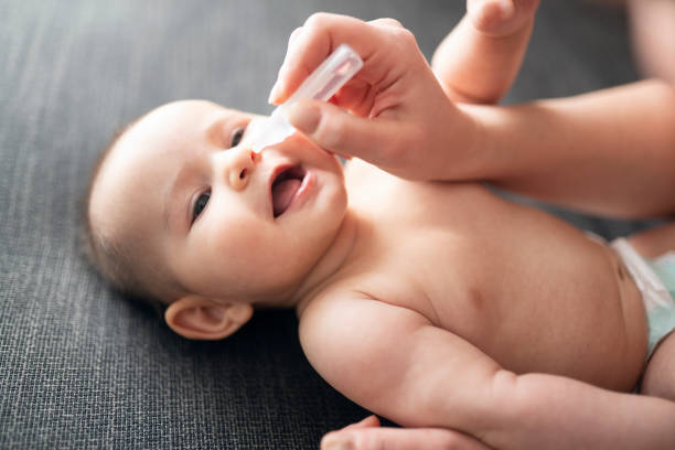 Newborn baby and nose drops stock photo
