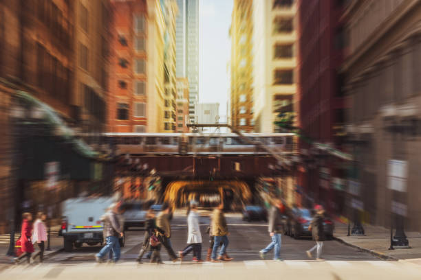 Blurred Crowd of Chicago street with traffic road intersection among modern buildings Blurred Crowd of Chicago street with traffic road intersection in rush hour among modern buildings of Downtown Chicago chicago illinois stock pictures, royalty-free photos & images