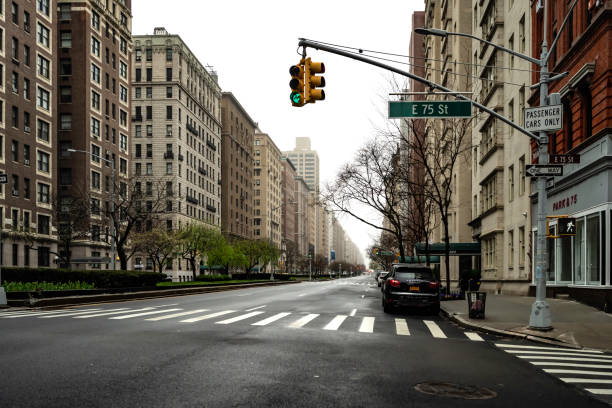 New York, NY, USA - March 29, 2020: Looking north up Park Avenue at East 75th Street on Manhattan's upper east side on a cold and rainy Sunday afternoon. The empty streets reflect the city-wide shut down due to the ongoing coronavirus pandemic.