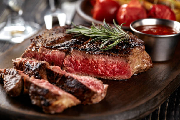 istock Juicy steak medium rare beef with spices on wooden board on table 1215698329