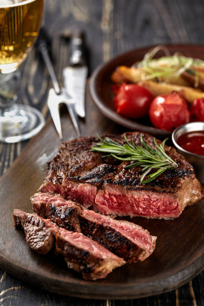istock Juicy steak medium rare beef with spices on wooden board on table 1215698390