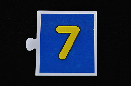 A jigsaw piece with the figure seven
