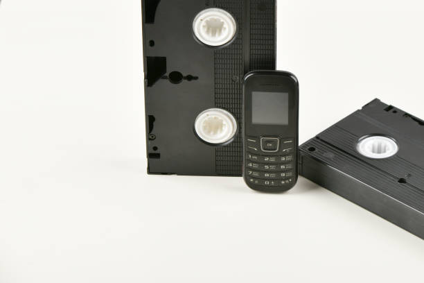 istock Retro objects on a white background. push-button telephone and video cassette. Analog media technology of the past. Copy space 1215700863