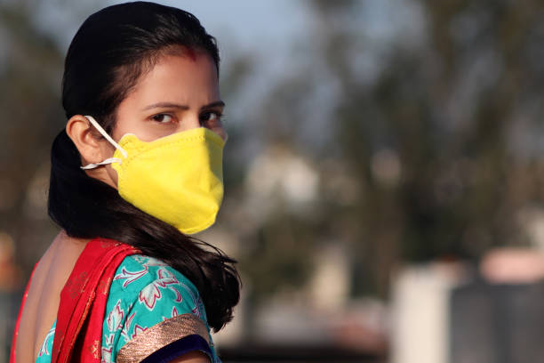 Women covering her face with pollution mask for protection from viruses stock photo