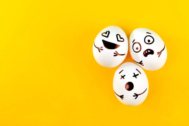 istock Easter eggs with different funny faces on yellow background. Top view. 1215705066