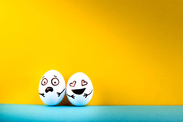 istock Easter eggs with different funny faces on blue and yellow background. 1215705107