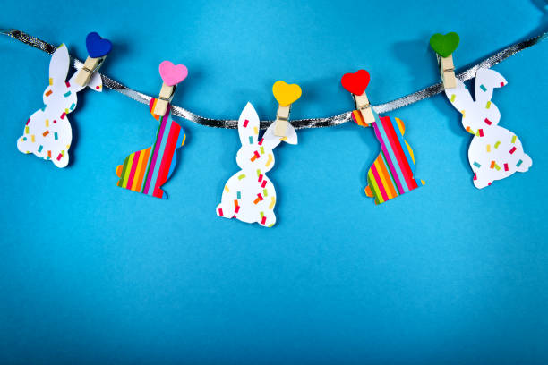 istock Garland with handmade Easter bunnies on blue background. Top view. Easter postcard. 1215705117