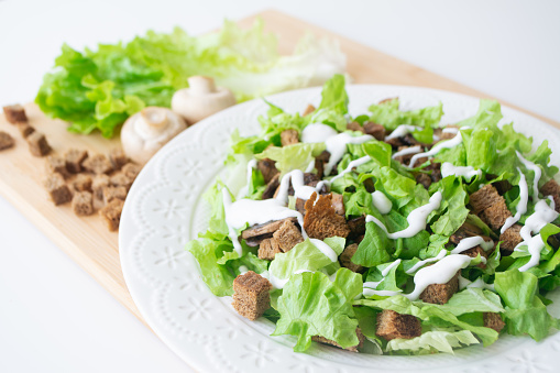 A vegetarian version of classic Caesar salad with mushrooms instead of chicken, croutons, lettuce, parmesan cheese and dressing sauce