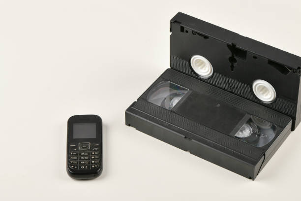 istock Retro objects on a white background. push-button telephone and video cassette. Analog media technology of the past. Copy space 1215706953