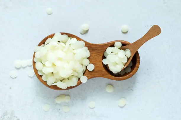 white natural beeswax pellets in white ceranic bowl for homemade natural beauty and D.I.Y. project.