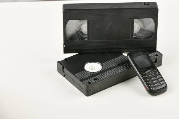 istock Retro objects on a white background. push-button telephone and video cassette. Analog media technology of the past. Copy space 1215708982