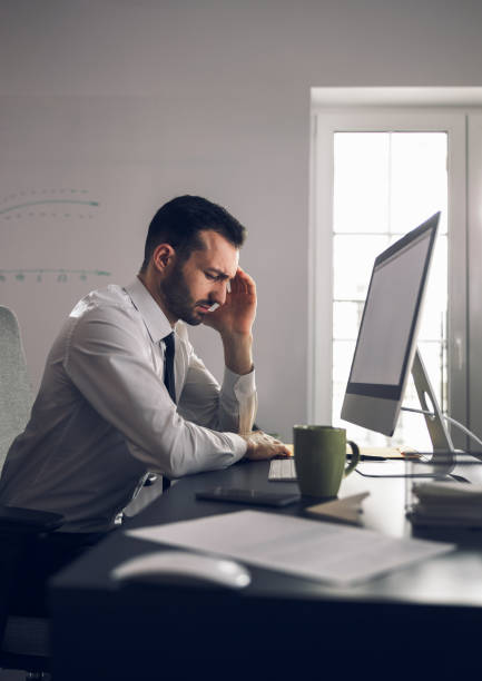 istock Nervous Caucasian man working at laptop in office 1215711955