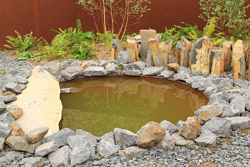 Small garden pond, embedded with stones and plants