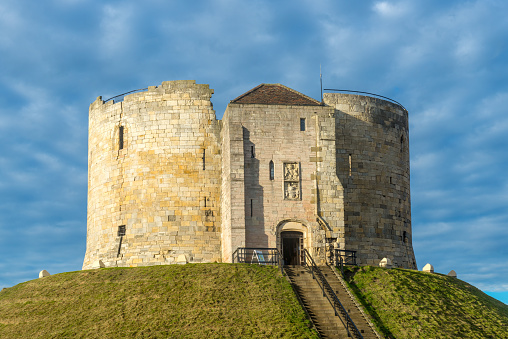 Clifford's Tower in York illuminated by early morning sunlight, Yorkshire, England, UK