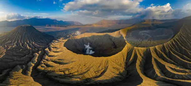 Panoramic aerial view of gas venting form an active volcano complex in late evening sunlight (Mount Bromo, Java, Indonesia)