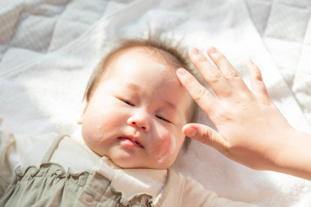 istock Baby having moisturizing cream applied in a bright room 1215717287