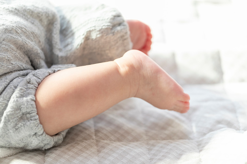 Baby feet lie down in a bright room